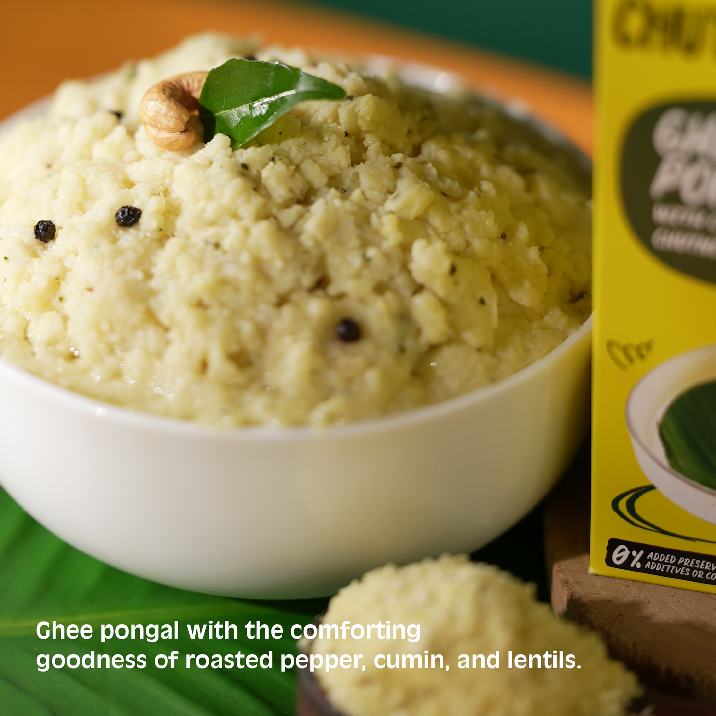 Bowl of ghee pongal with roasted pepper, cumin, and lentils next to a box of ChitTAGOG Ghee Pongal.