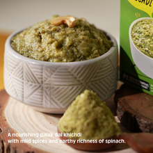 Bowl of palak dal khichdi with a box in the background on a wooden surface